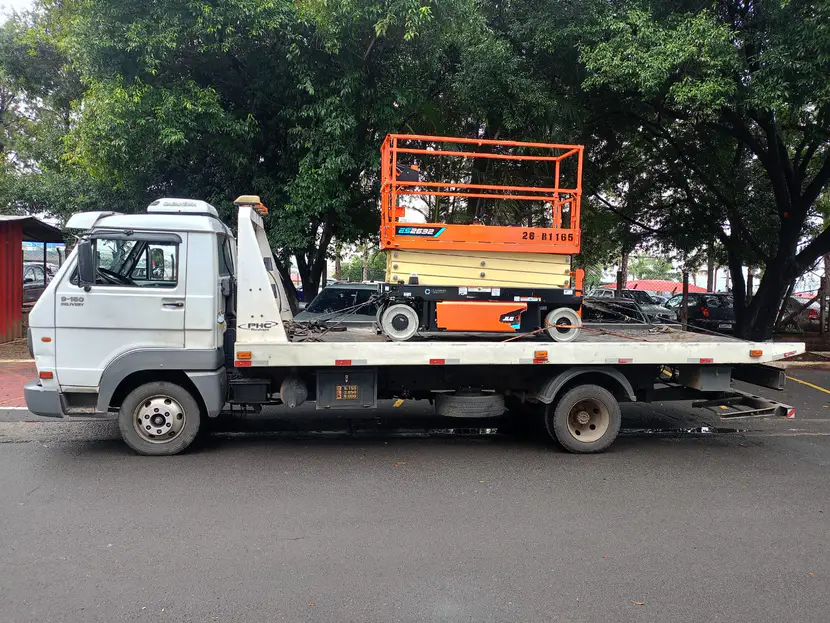 Plataforma elevatória tipo tesoura sobre a plataforma do caminhão.